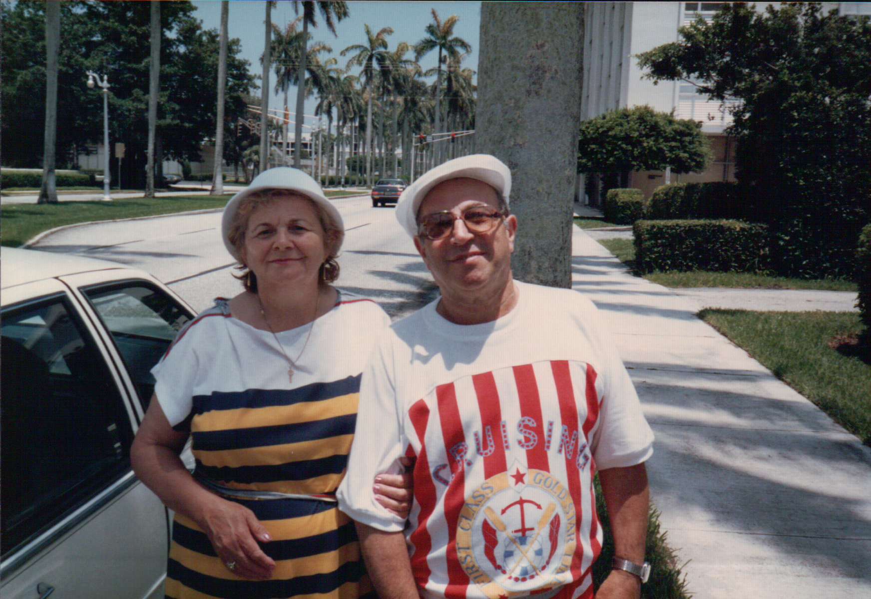 Masha and Alexander on a palm-lined street in Florida.