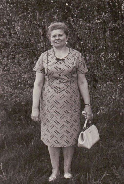 Masha standing outdoors in a summer dress.