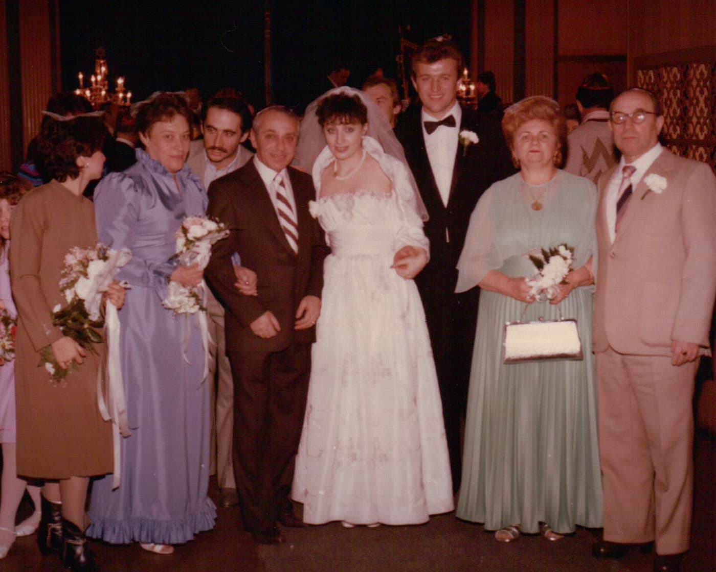 Family wedding photo. Bride and groom with Masha in green and Alexander in tan suit.
