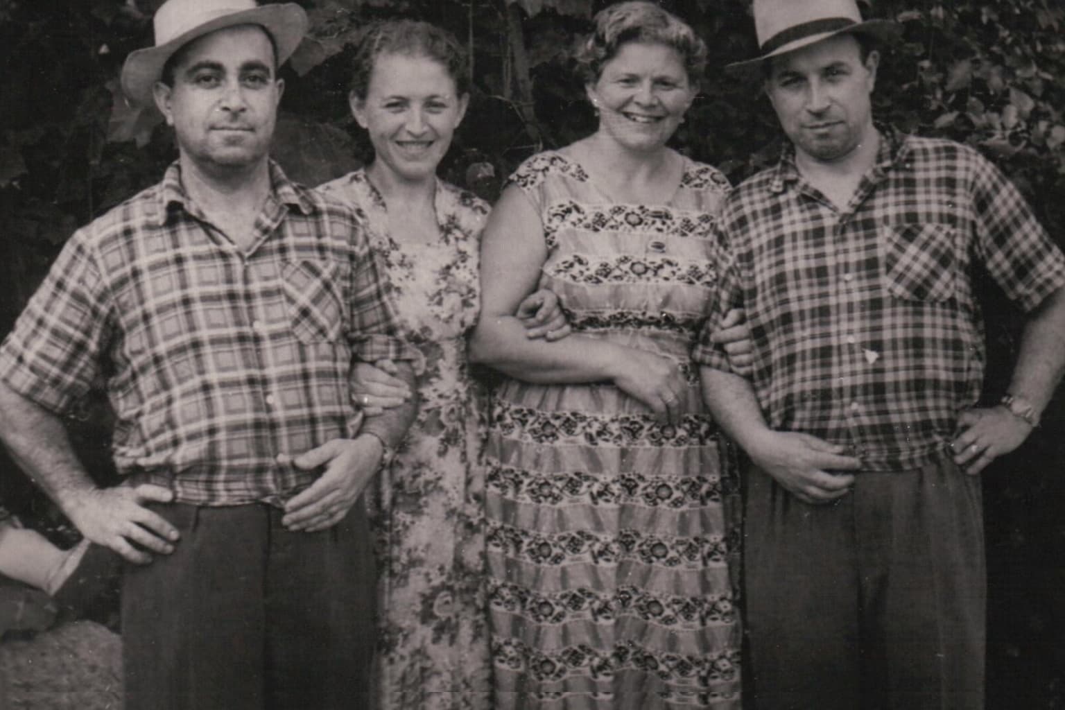 Two couples outdoors in summer, straw hats. Masha and Alexander with friends.